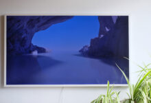 Photograph of Samsung The Frame TV mounted to wall with some spider plants in bottom right corner